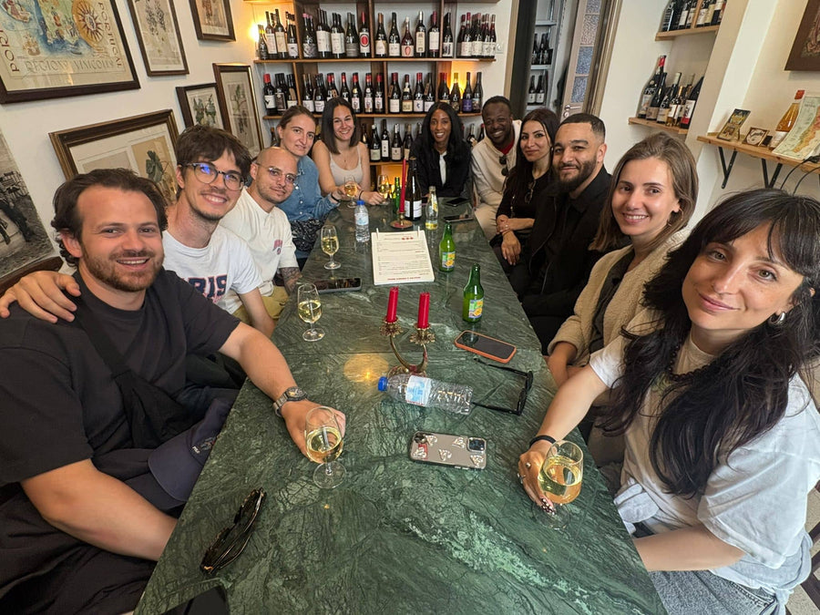 Friends celebrating around the marble table at a private wine tasting at POP, Lisbon